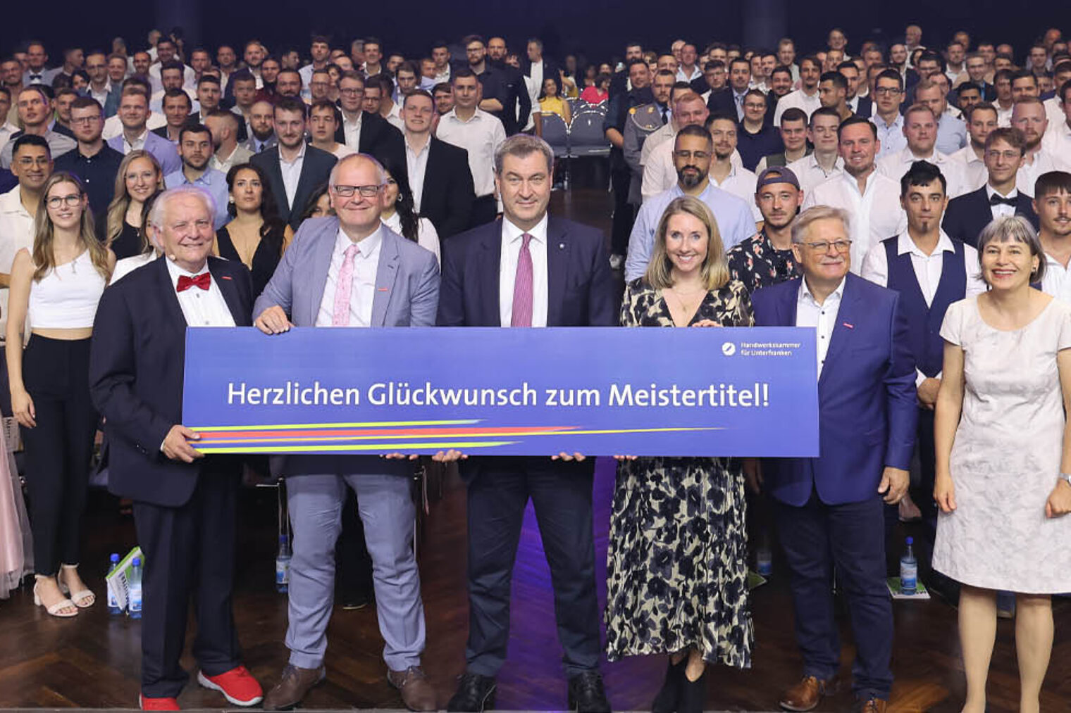 Foto der Meister 2024 in den Saal, im Vordergrund Ehrengäste um Dr. Markus Söder