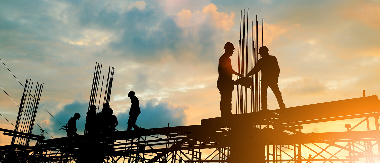 Konjunktur Q3/2024 Totale eine Baustelle mit Bauarbeitern im Sonnenuntergang