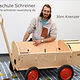Porträt von Jörn Krenzer mit seinem Schreinermeisterstück "Bollerwagen Wilfried".