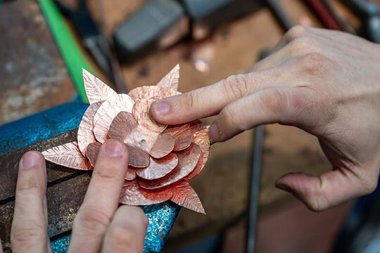 Herstellen einer Spenglerrose auf der Messe Dach+Holz 2024 