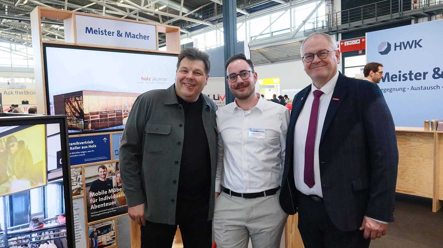 Gruppenfoto drei Personen an Messestand