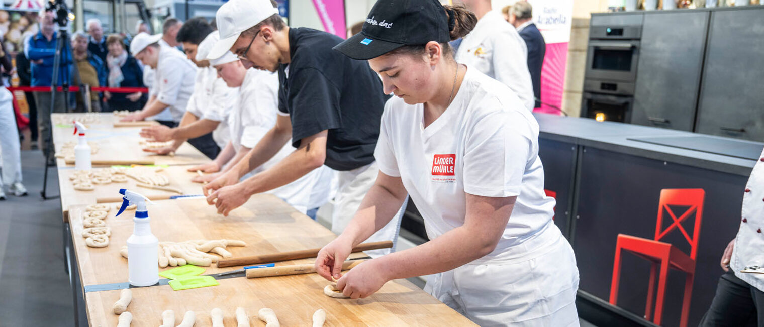 Bäcker beim Wettbewerb auf Messe formen Teig