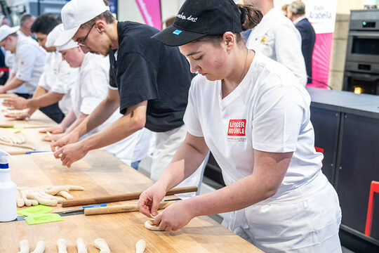Bäcker beim Wettbewerb auf Messe formen Teig
