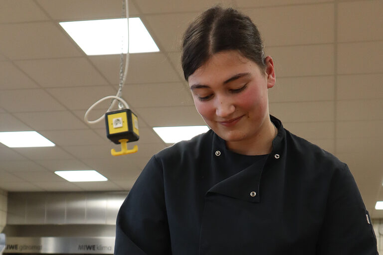 Bäckerin in Backstube formt Teig