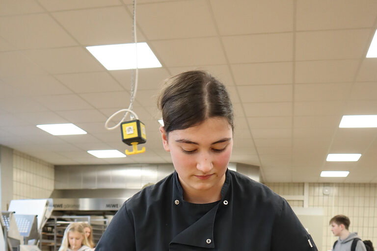 Bäckerin in Backstube formt Teig